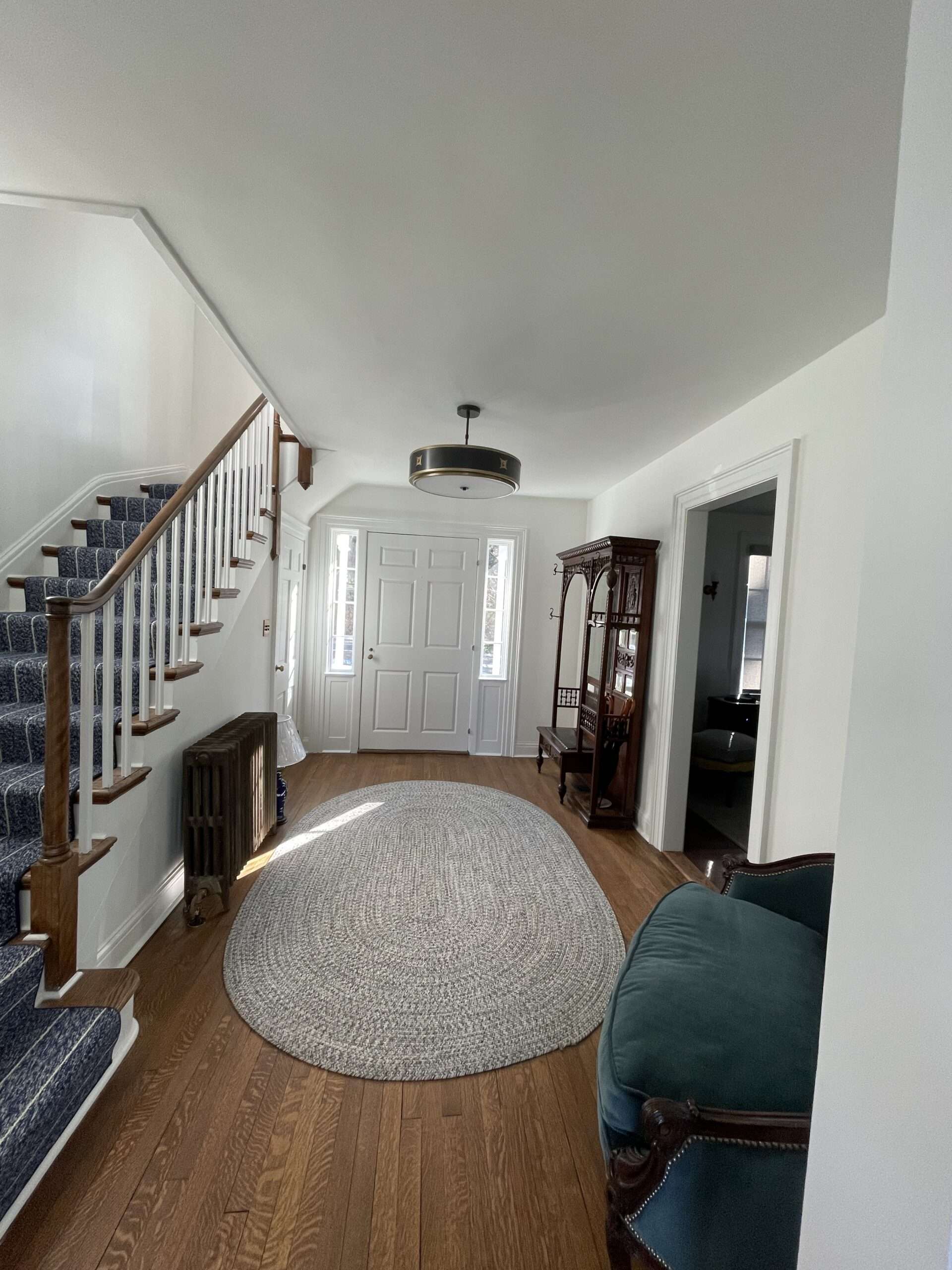 Bright white foyer and staircase with freshly painted trim in a Westchester home